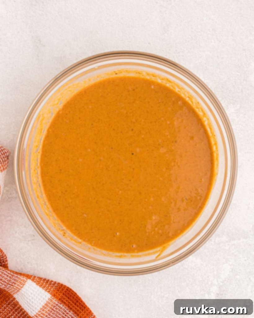 Air Fryer Pumpkin Pie 5 Golden orange pumpkin filling in a clear glass bowl.
