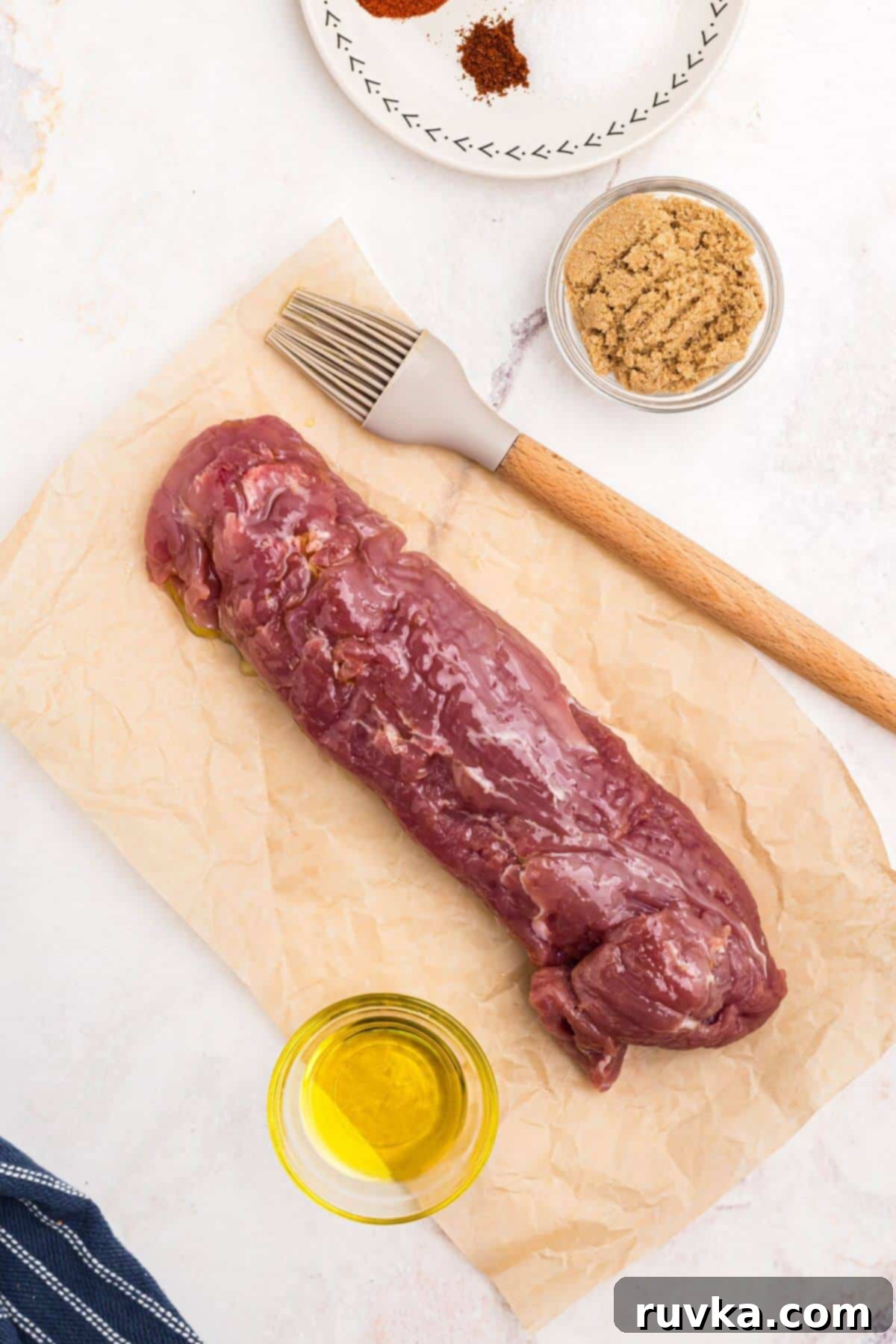Tender Air Fryer Pork Tenderloin in a Flash 4 Uncooked pork tenderloin after being lightly brushed with olive oil, before being coated with seasonings.