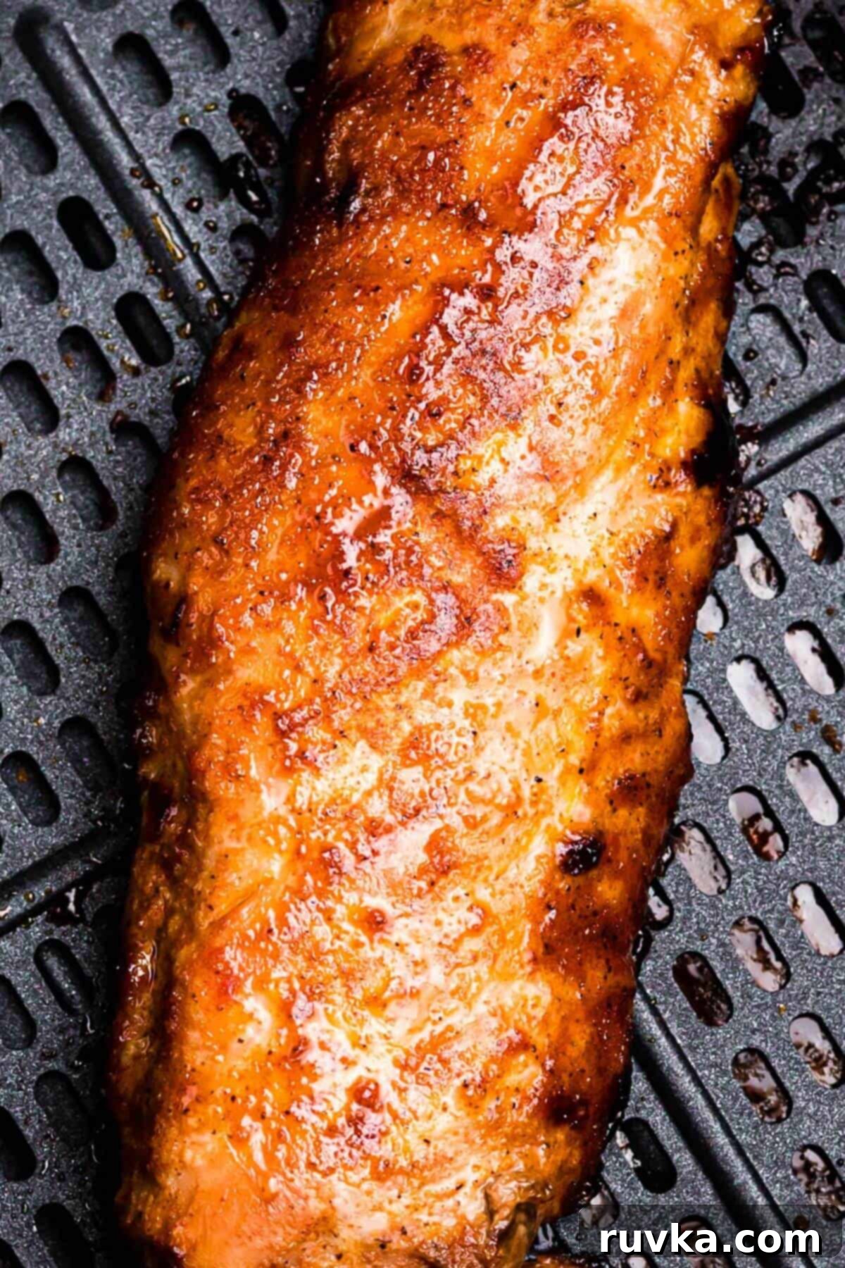 Tender Air Fryer Pork Tenderloin in a Flash 8 Crispy coated seasoned pork tenderloin in the air fryer basket after being cooked.