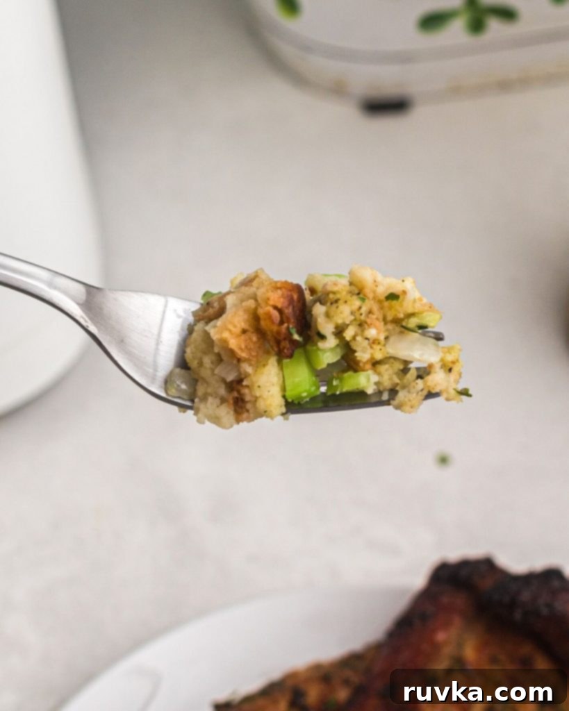 Perfectly Crispy Air Fryer Stuffing 8 Spoonful of stuffing on a fork showing onion and celery mixed with golden breadcrumbs.