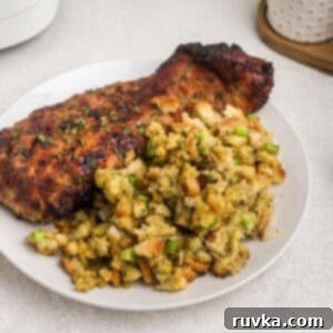Perfectly Crispy Air Fryer Stuffing 9 Golden stuffing with green celery and chopped onions served on a white plate with pork tenderloin.