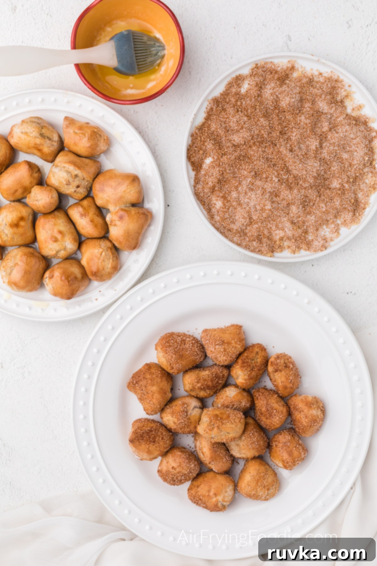 Air Fried Pretzel Perfection 11 Air Fryer Pretzel bites on a white plate dipped in cinnamon sugar mixture.