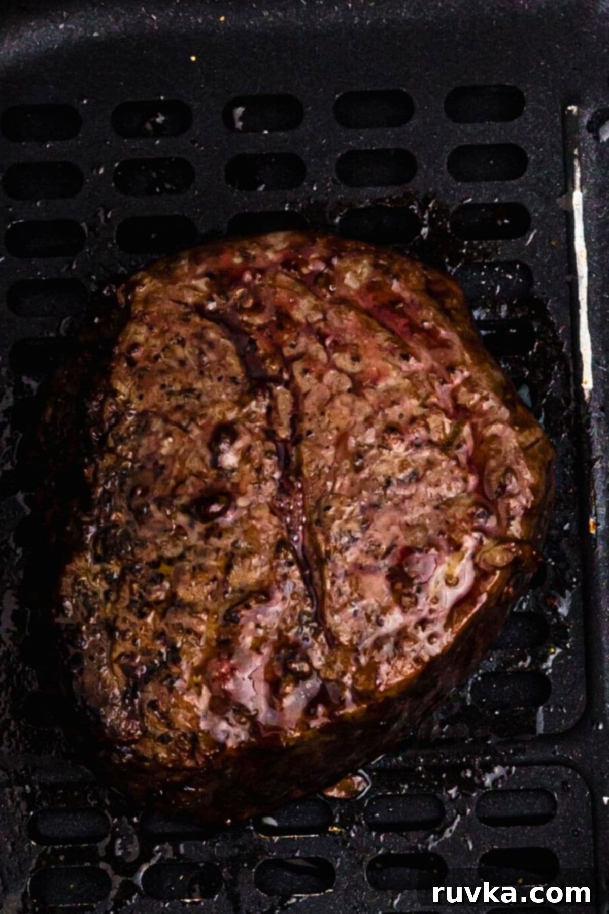 Perfect Air Fryer Filet Mignon 2 Juicy filet in the air fryer basket after being cooked.