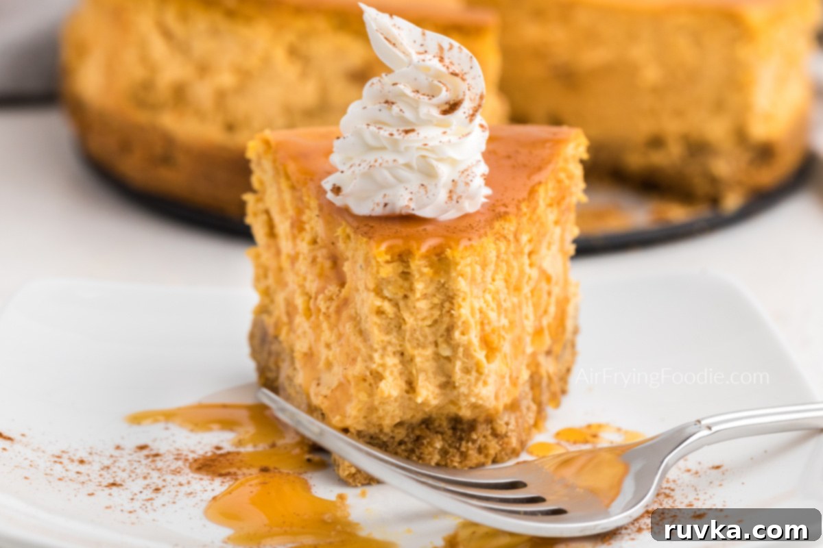 Air Fryer Pumpkin Cheesecake 13 Bite shot of air fryer pumpkin cheesecake with caramel, icing, and a dusting of cinnamon.