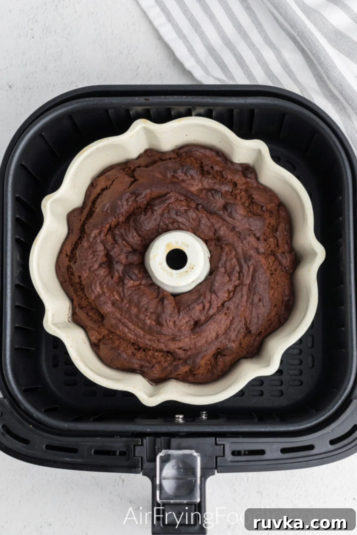 Irresistible Air Fryer Chocolate Bundt 8 Freshly cooked chocolate bundt cake still in its pan, nestled inside the air fryer basket after baking.