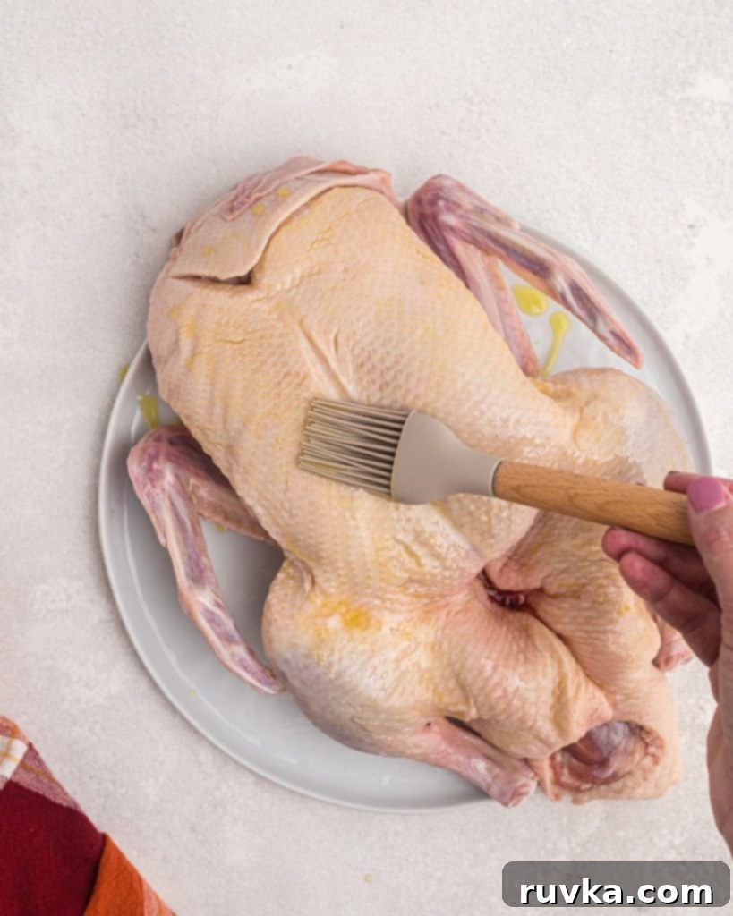 Crispy Air Fryer Duck 5 Duck being brushed with olive oil using a pastry brush.