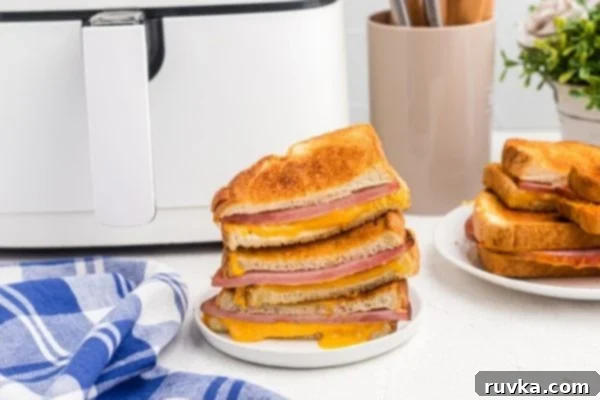 Air Fryer Golden Ham and Cheese Melt 2 Golden crispy ham and cheddar cheese sandwiches made in the air fryer basket.