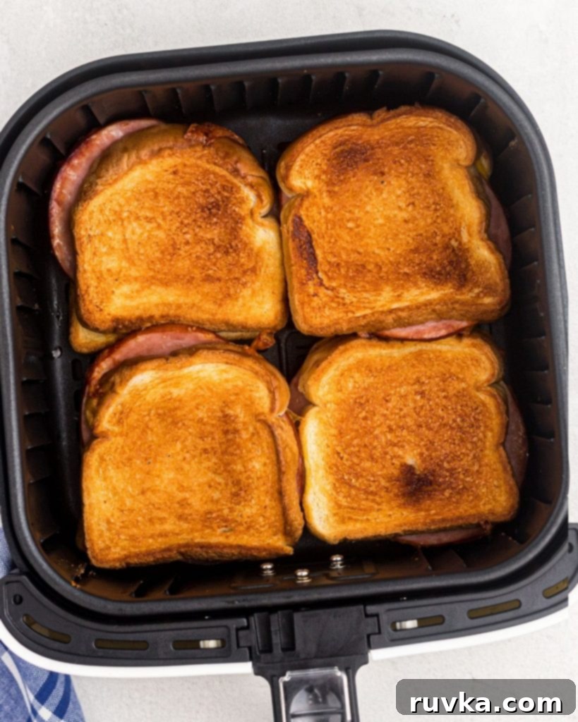 Air Fryer Golden Ham and Cheese Melt 6 Four golden cooked grilled ham and cheese sandwiches in the air fryer.