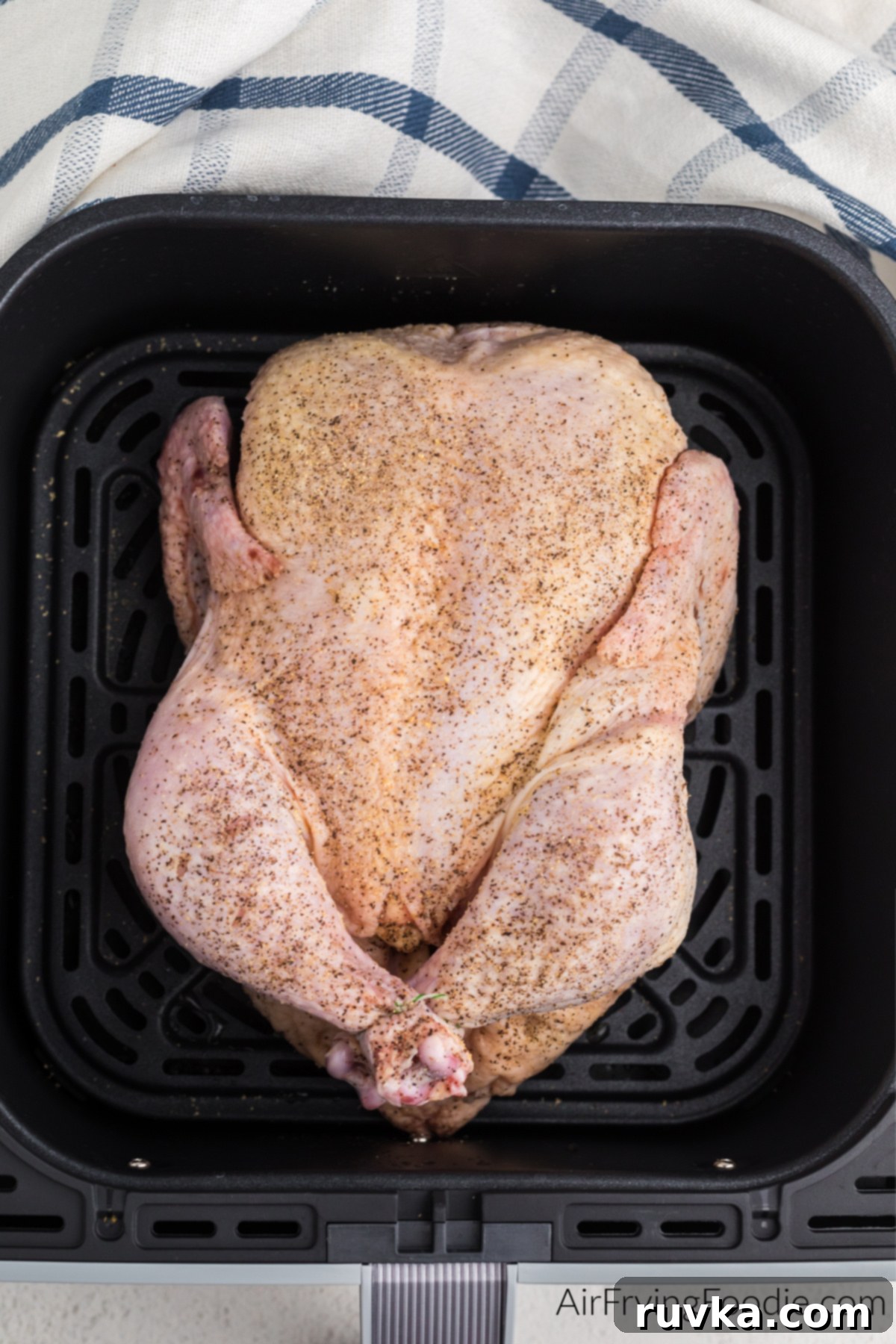 Crispy Air Fryer Whole Chicken 4 Seasoned whole chicken in air fryer basket.
