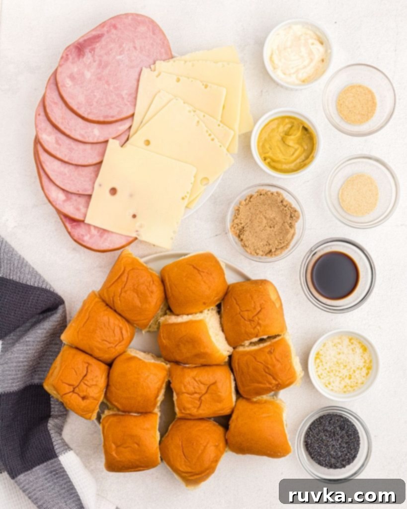 Irresistible Air Fryer Ham and Cheese Sliders 3 A flat lay image displaying all the fresh ingredients needed to prepare delicious air fryer ham and cheese sliders, including rolls, ham, cheese, and various glaze ingredients.