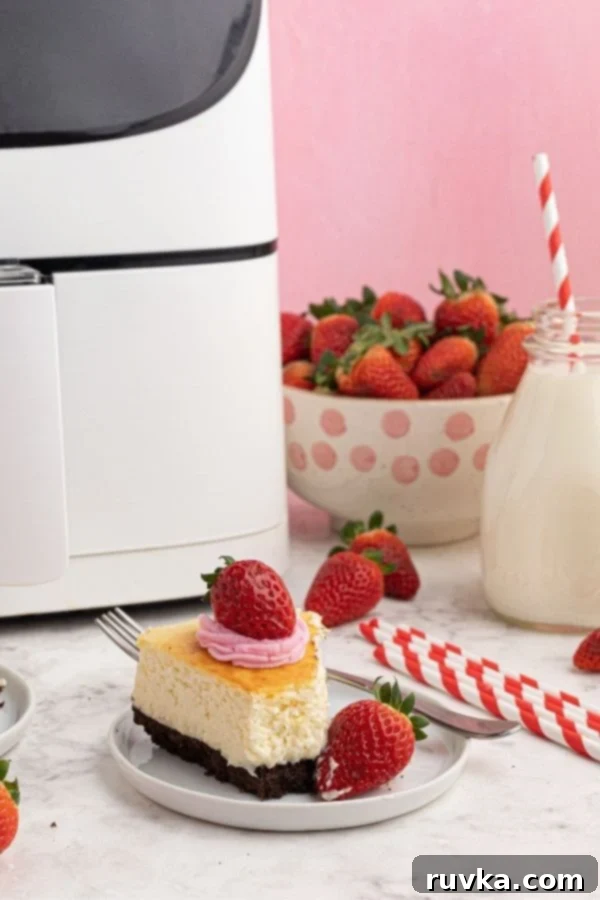 Effortless Air Fryer Cheesecake 5 A perfect slice of creamy air fryer cheesecake, served on a white plate, revealing its smooth texture and chocolate cookie crust.