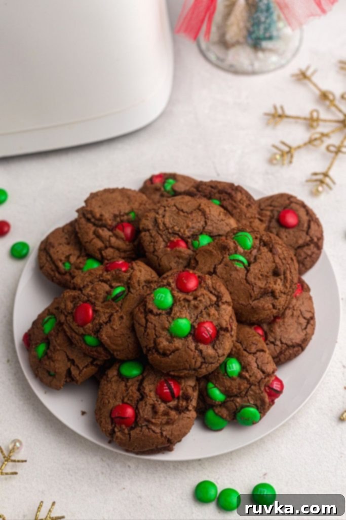 Quick Christmas Air Fryer Brownie Bites 2 Fudgy brownie cookies with vibrant red and green candies baked in, beautifully arranged on a pristine white plate, ready to be enjoyed.