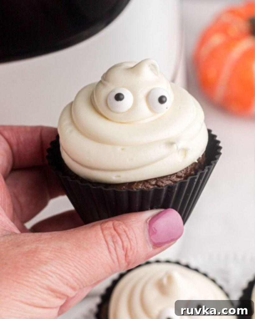 Spooktacular Air Fryer Ghost Cupcakes 8 Close up photo of a ghost cupcake showing the eyes and mound of frosting.