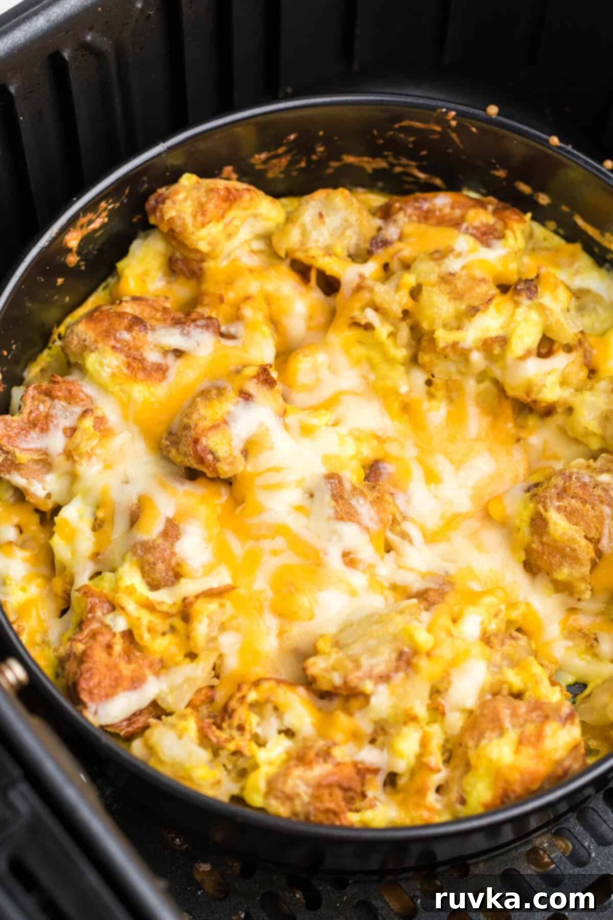 Crispy Air Fryer Breakfast Bowl 6 air fryer breakfast bowl with chicken, cheese, eggs, tater tots, and topped with cheese. Ready to serve.