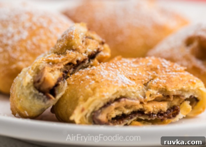 Air Fryer Tagalongs 6 Air Fried Tagalong Girl Scout Cookies topped with powdered sugar on a white plate with one broken in half.