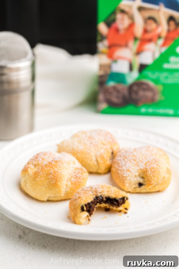 Warm Air-Fried Thin Mints 2 Air Fried Thin Mints on a white plate and topped with powdered sugar.