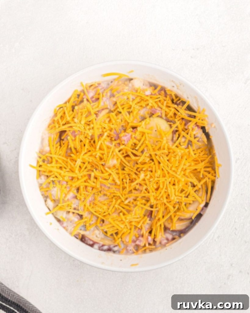 Air Fryer Golden Ham and Potato Bake 4 Bowl of ham and potato casserole ingredients mixed together before cooking, showcasing the creamy sauce and chunks of ham and potatoes.