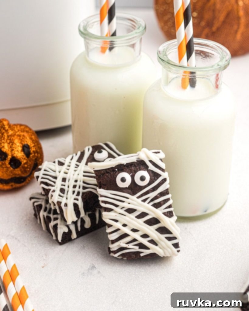 Halloween Air Fryer Mummy Brownies 3 close up of mummy brownies stacked and in front of two small milk bottles with straws.