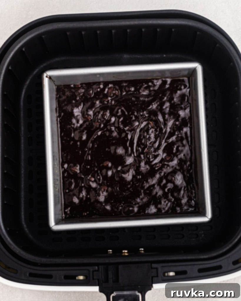 Halloween Air Fryer Mummy Brownies 6 Square baking pan in an air fryer basket before being cooked.