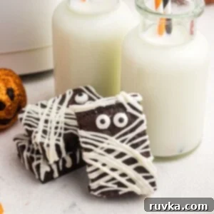 Spooktacular Air Fryer Charcuterie Board 5 Fudgy air-fried brownies decorated like mummies with white frosting and candy eyes, creating a cute Halloween dessert.