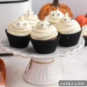 Spooktacular Air Fryer Charcuterie Board 8 Delicious chocolate cupcakes topped with ghost-shaped vanilla frosting and candy eyes, perfect for Halloween parties.