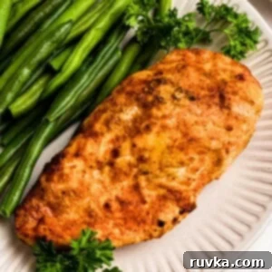 Crispy Air Fryer Chicken Bites 9 Golden, air fried chicken on a white plate with green beans.