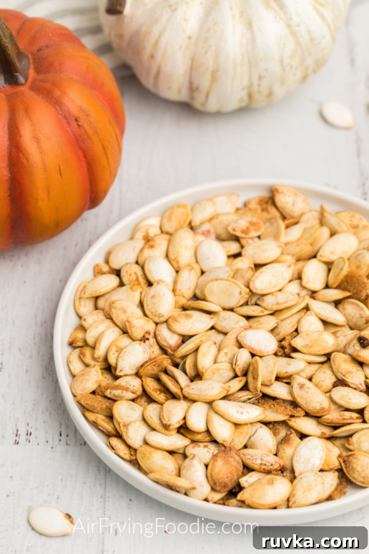 Crispy Air Fryer Pumpkin Seeds 2 Roasted Air Fryer Pumpkin Seeds on a white plate ready to serve.