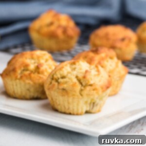 Easy Air Fryer Banana Muffins 8 Banana Muffins on a white plate ready to eat.