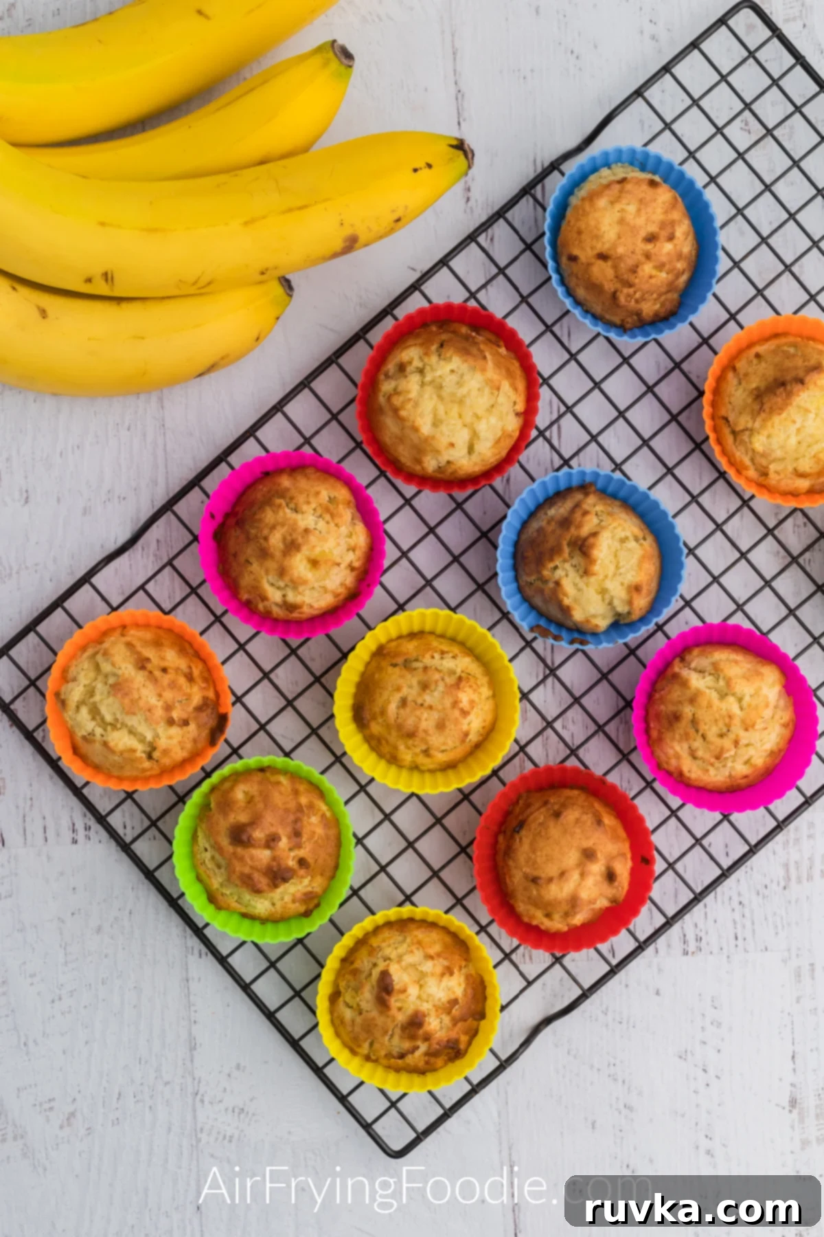 Easy Air Fryer Banana Muffins 6 Banana muffins cooling on a wire rack.