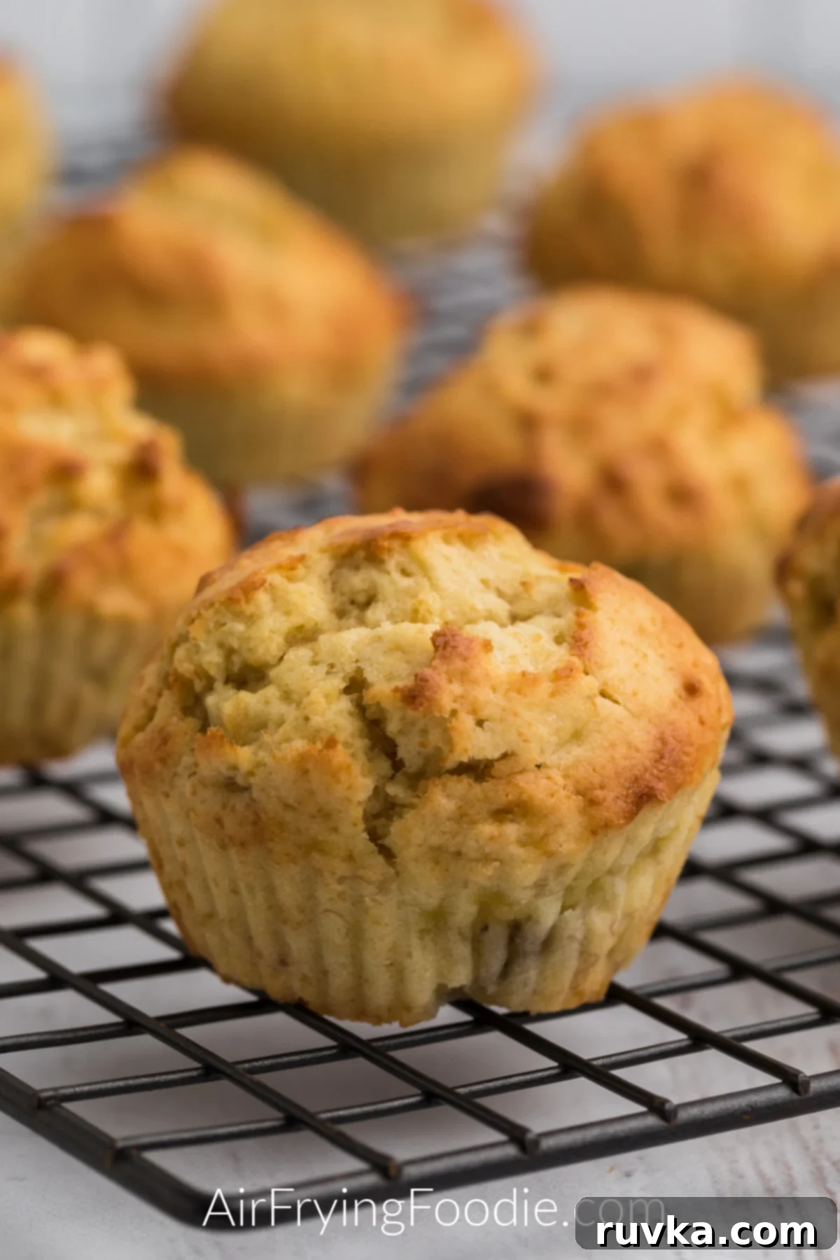 Easy Air Fryer Banana Muffins 7 Close up photo of banana muffins on a cooling rack.