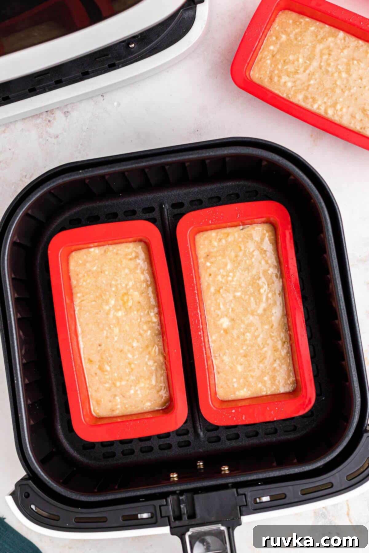 Banana bread batter in mini loaf pans ready for air frying. 