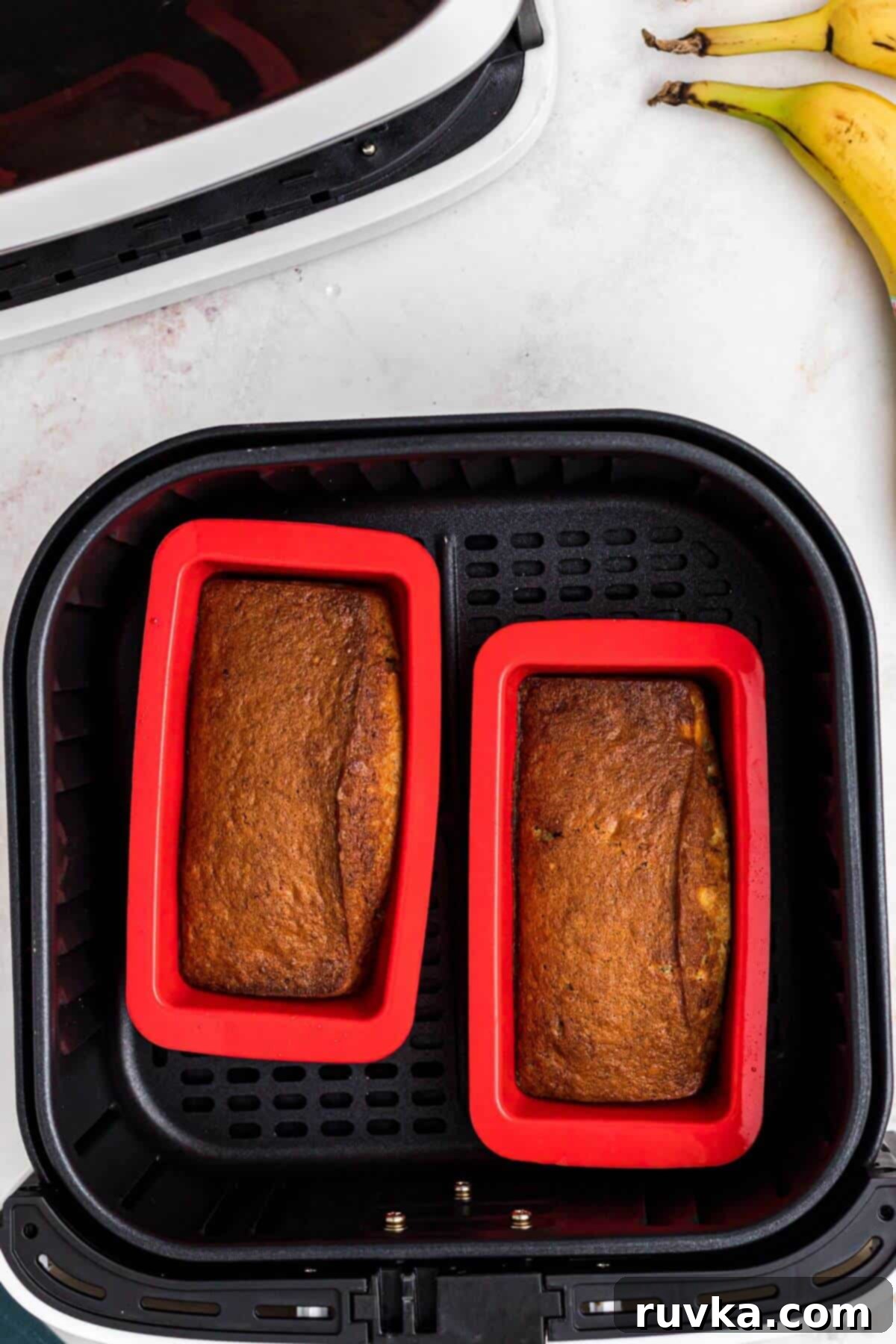 Baked banana bread in red silicone mini loaf pans. 