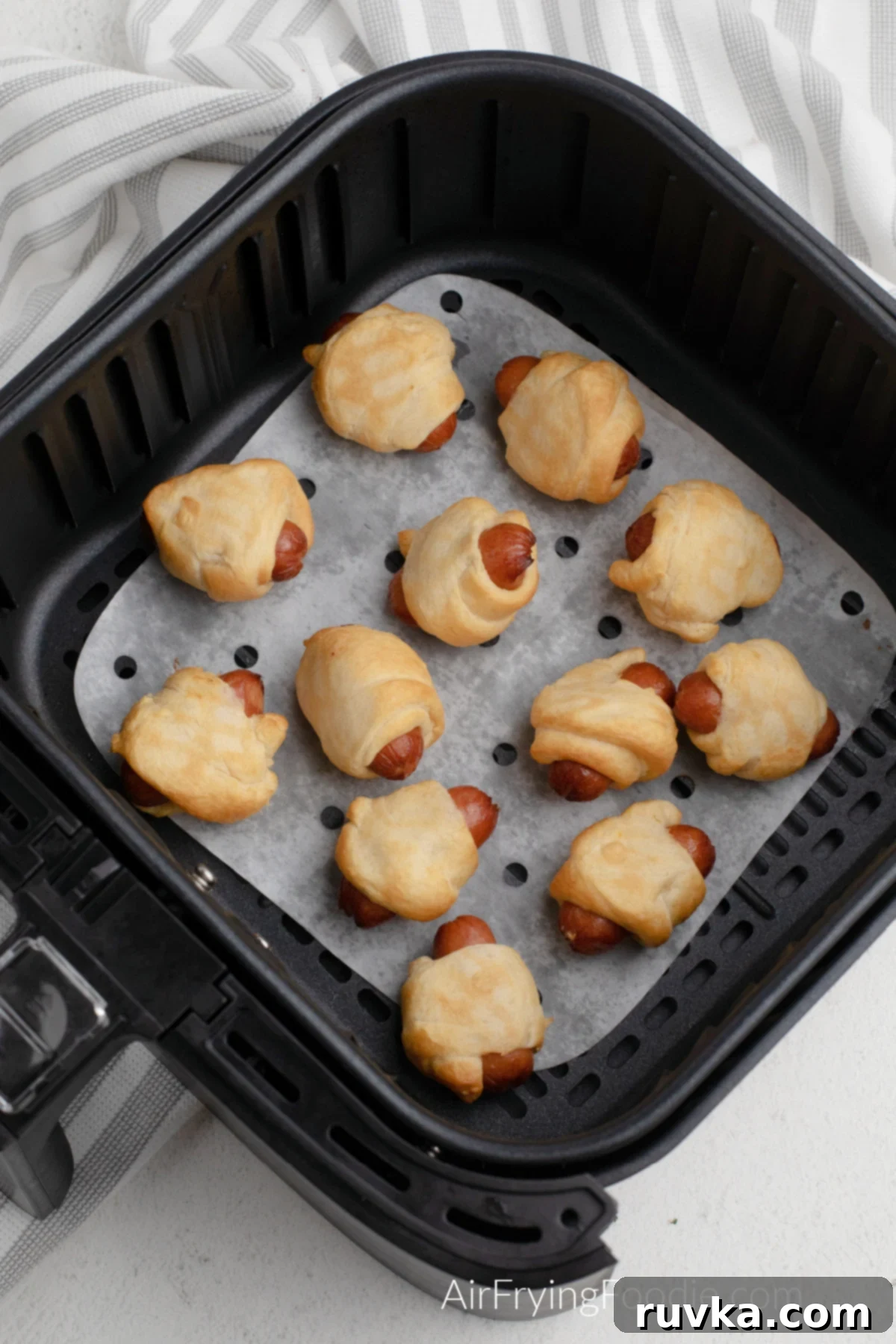 Golden Air-Fried Sausage Bites 5 Batch of air fried pigs in a blanket in the basket of the air fryer, showing their golden-brown finish.