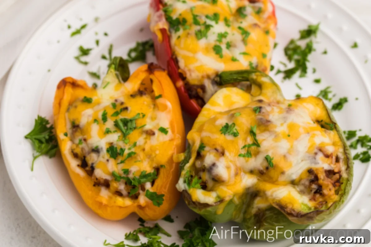Effortless Air Fryer Stuffed Peppers 6 Stuffed bell peppers made in the air fryer on a white plate and ready to serve.