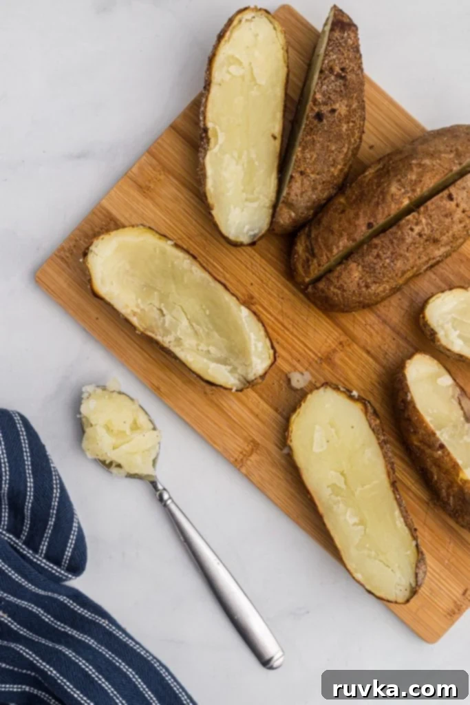 Ultimate Air Fryer Twice Baked Potatoes 5 Spoon scooping out potato meat to empty skins.