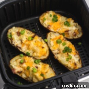 Ultimate Air Fryer Twice Baked Potatoes 10 Close up photo of twice baked potatoes after being cooked in the air fryer basket