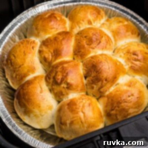 Air Fryer Thanksgiving Feast Made Easy 13 Close up photo of golden rolls in the air fryer basket.