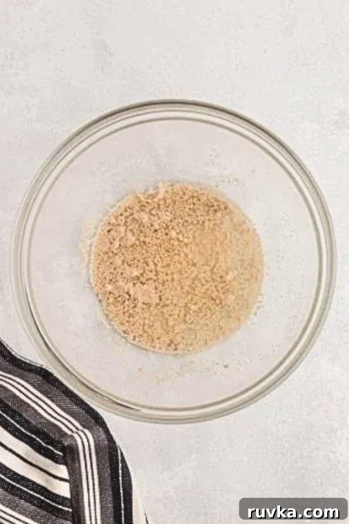 Bake Bread in Your Air Fryer 4 Yeast in a clear glass bowl, mixed with warm water and blooming.