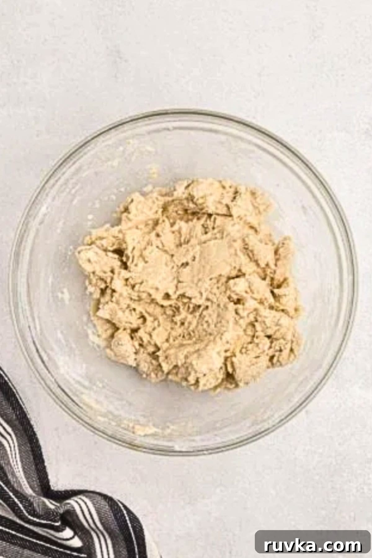 Bake Bread in Your Air Fryer 5 Flaky bread dough mixed together in a clear glass bowl.