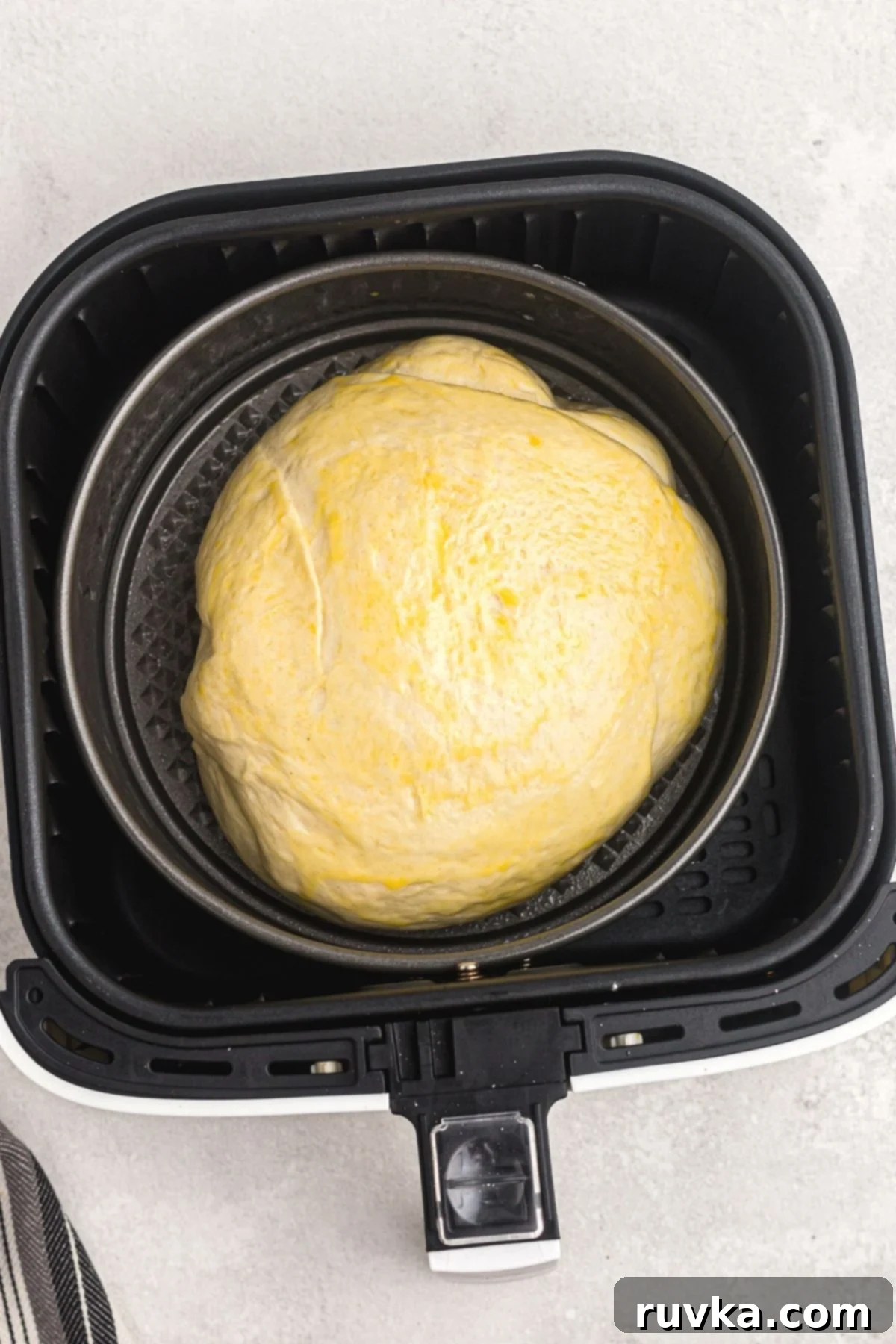 Bake Bread in Your Air Fryer 7 Uncooked bread dough that has risen, in a springform pan, in the air fryer basket.
