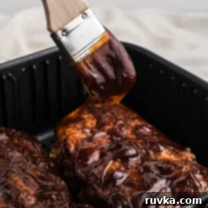 Ultimate Air Fryer BBQ Ribs 10 AIr Fryer BBQ Ribs with extra sauce being added.