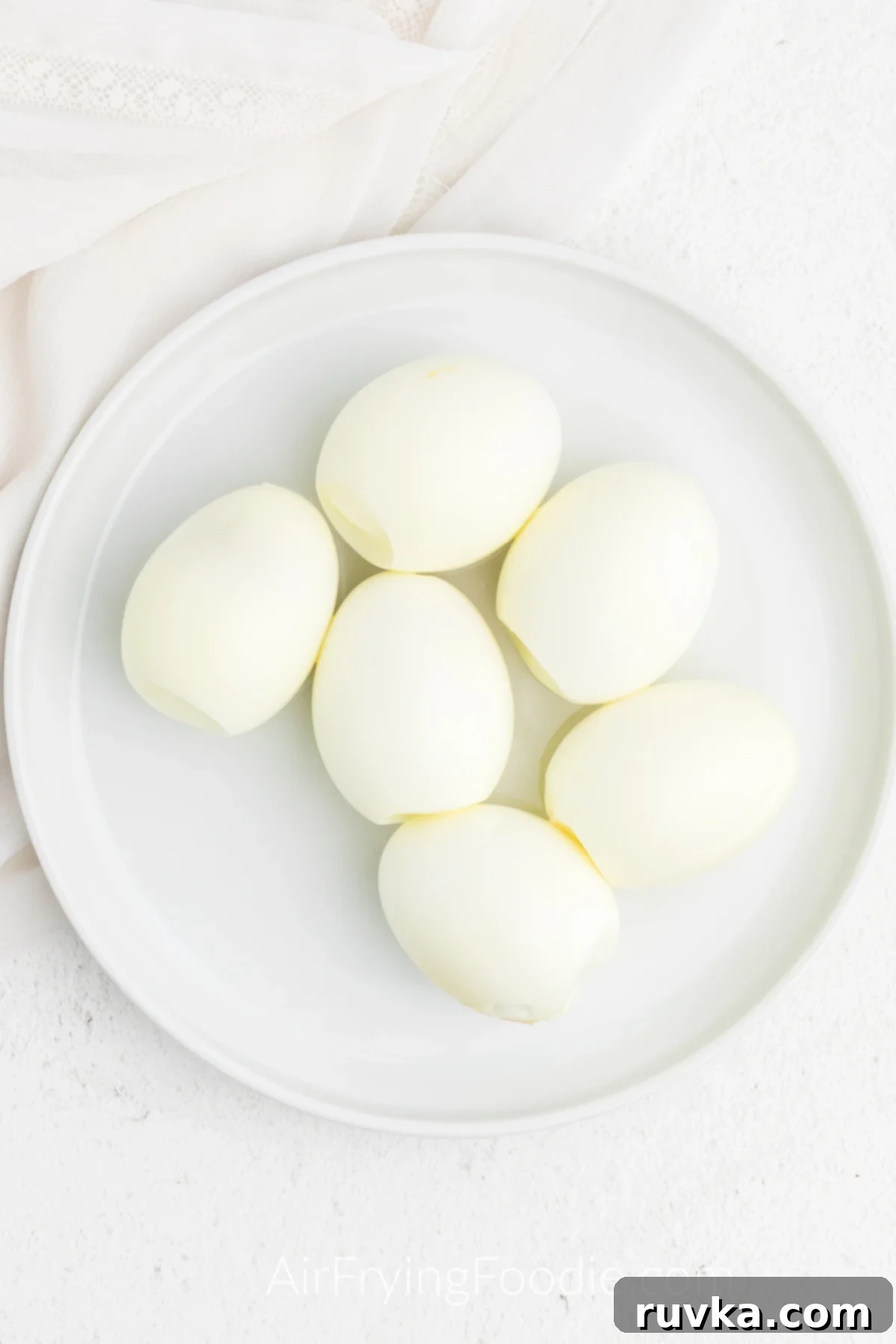 Boil-Free Hard Boiled Eggs in Your Air Fryer 5 Hard boiled eggs peeled and on a plate.