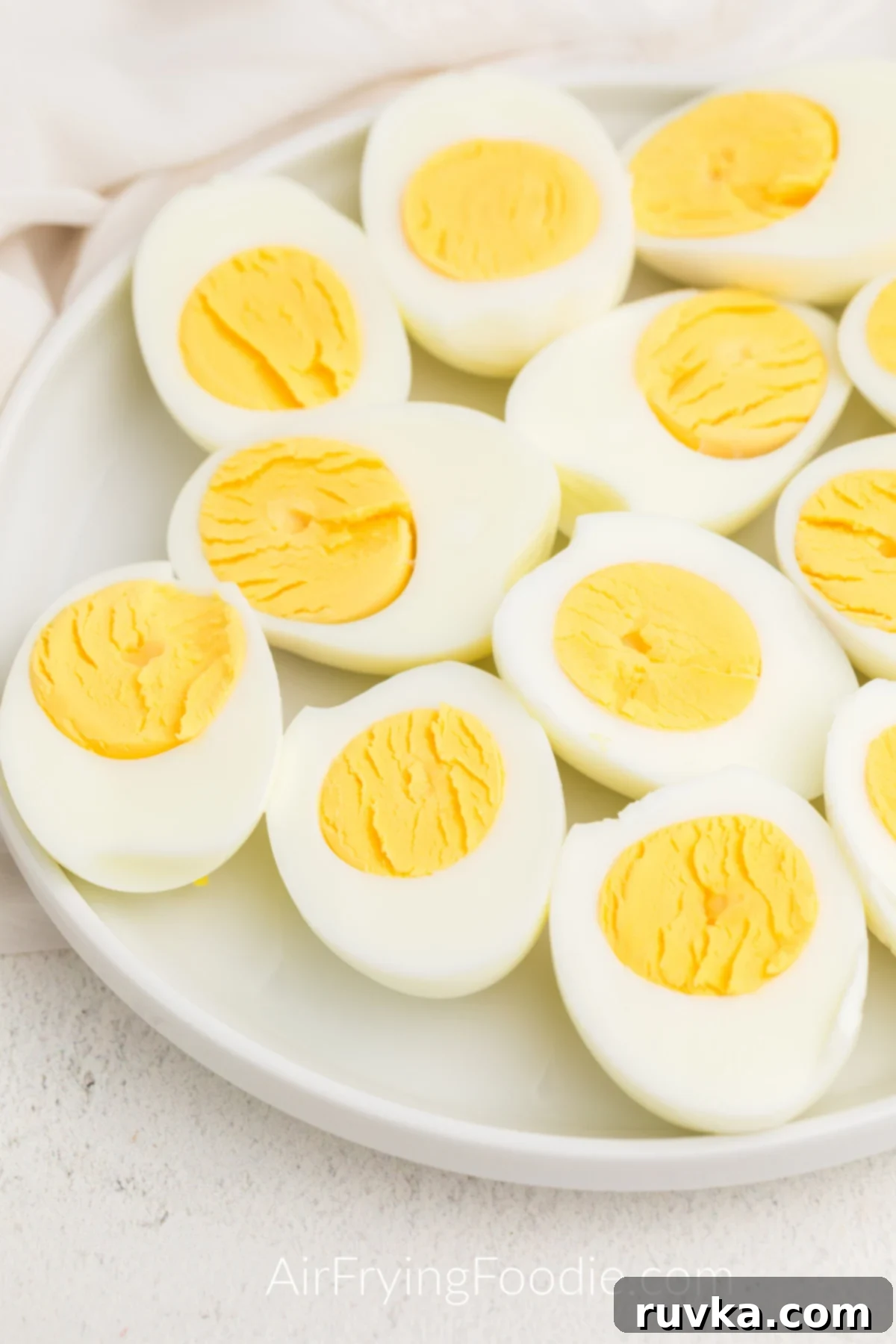 Boil-Free Hard Boiled Eggs in Your Air Fryer 7 Plate of hard boiled eggs sliced in half.