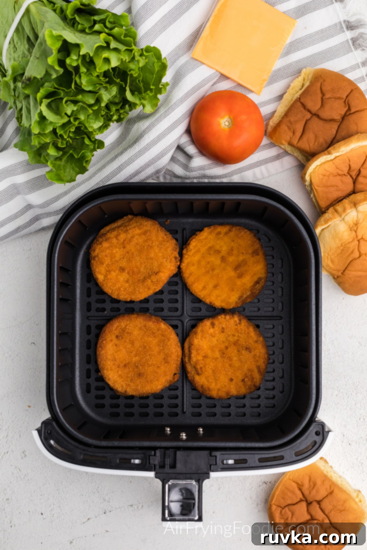 Quick and Crispy Air Fryer Frozen Chicken Patties 4 Assortment of fresh ingredients including brioche buns, crisp lettuce, juicy tomato slices, and cheddar cheese, laid out and ready for assembling delicious chicken patty sandwiches.