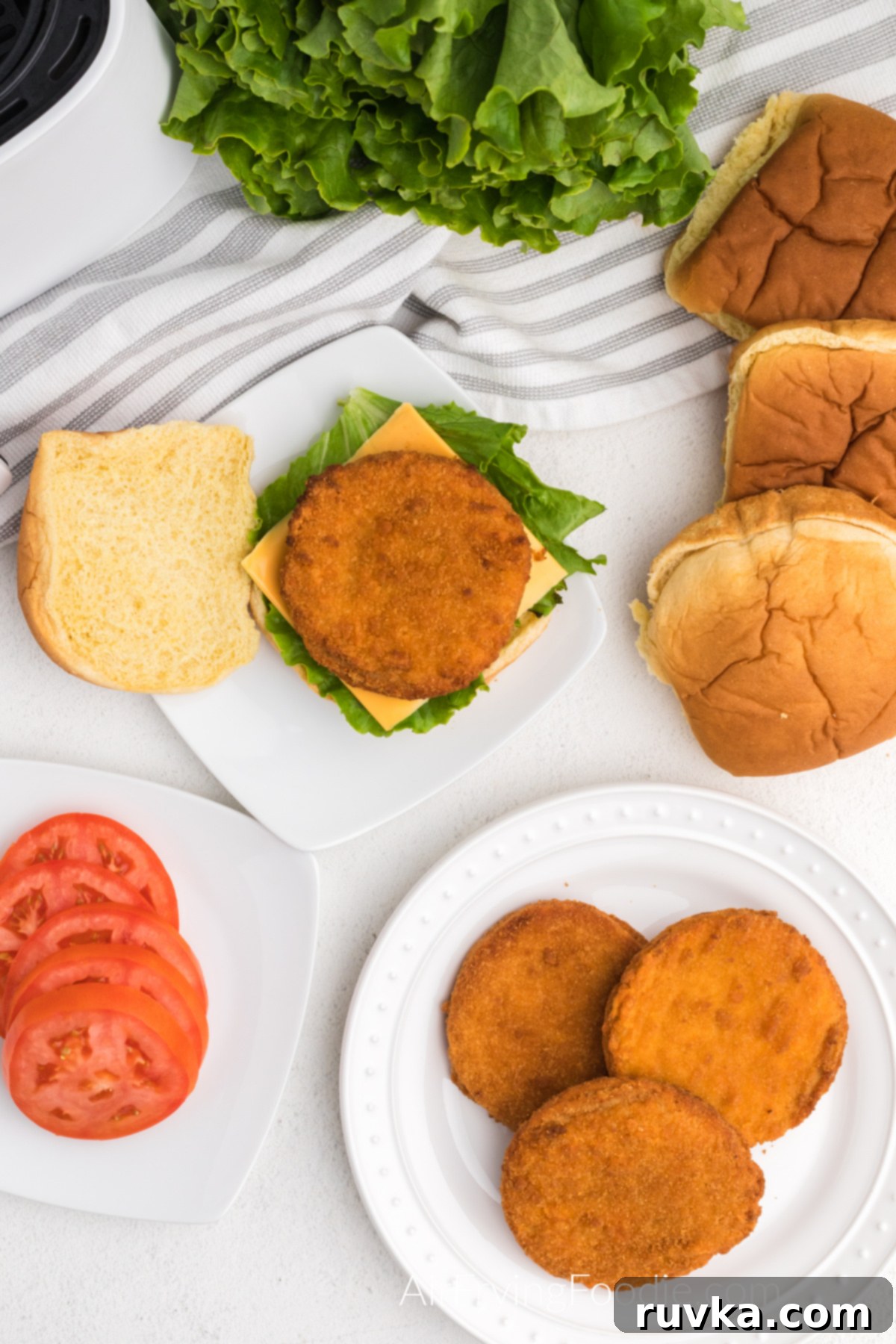 Quick and Crispy Air Fryer Frozen Chicken Patties 6 Assembled chicken patty sandwiches with melted cheese, fresh lettuce, and ripe tomato slices on toasted buns.