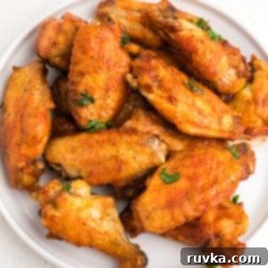 Crispy Air Fryer Chicken Wings 6 Crispy Air Fryer chicken wings on a white plate ready to serve.