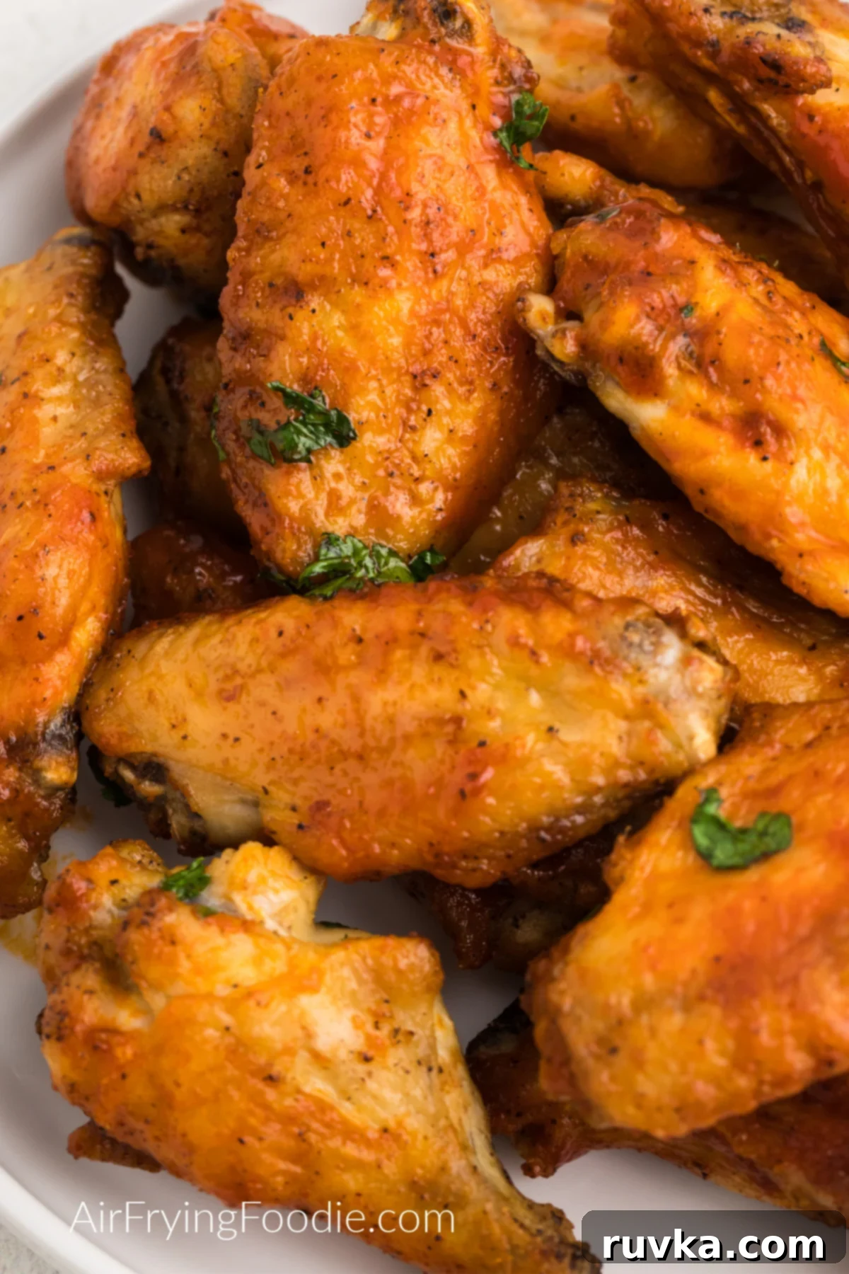 Crispy Air Fryer Chicken Wings 3 Close up of seasoned crispy air fryer chicken wings on a white plate ready to serve.