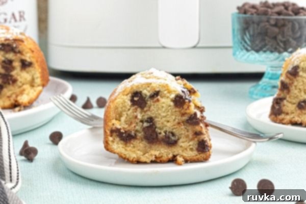 Air Fried Chocolate Chip Pound Cake 2 Cut slice of chocolate chip pound cake, served on a white plate, cooked in the air fryer with chocolate chips scattered around the table.