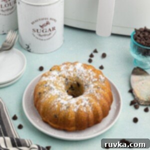 Air Fried Chocolate Chip Pound Cake 6 Round golden Bundt cake with chocolate chips scattered and in front of the air fryer.