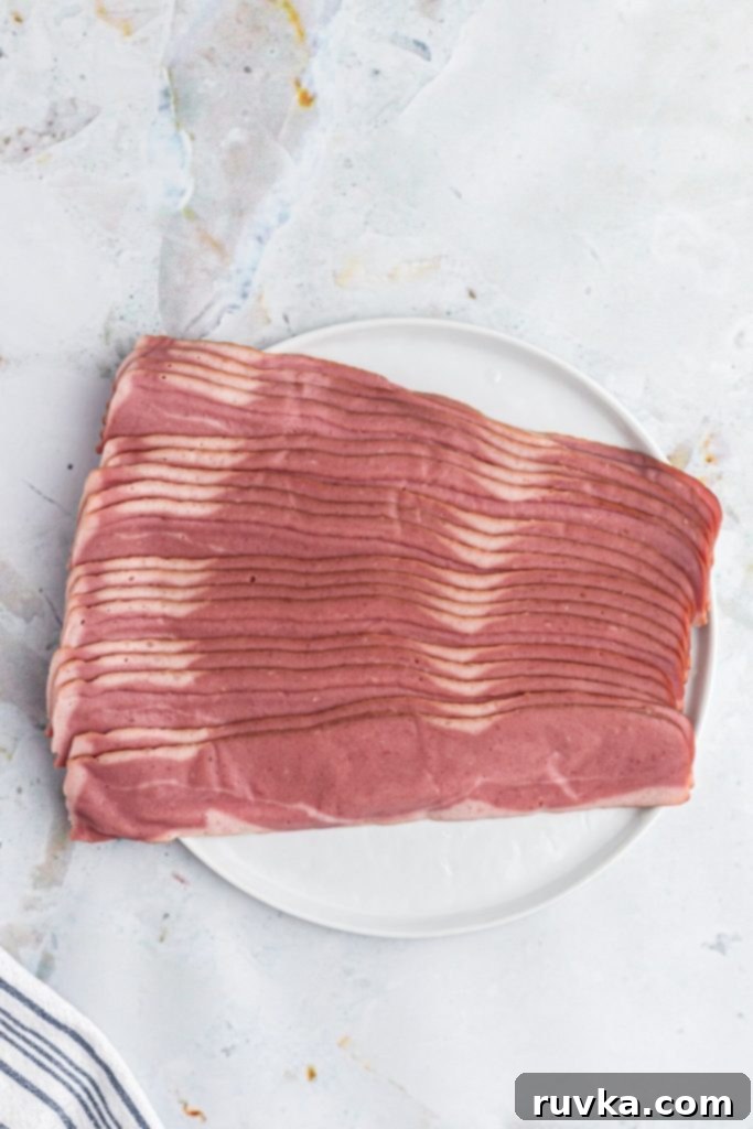 Crispy Air Fryer Turkey Bacon 3 Package of uncooked turkey bacon on a white plate, ready for the air fryer.